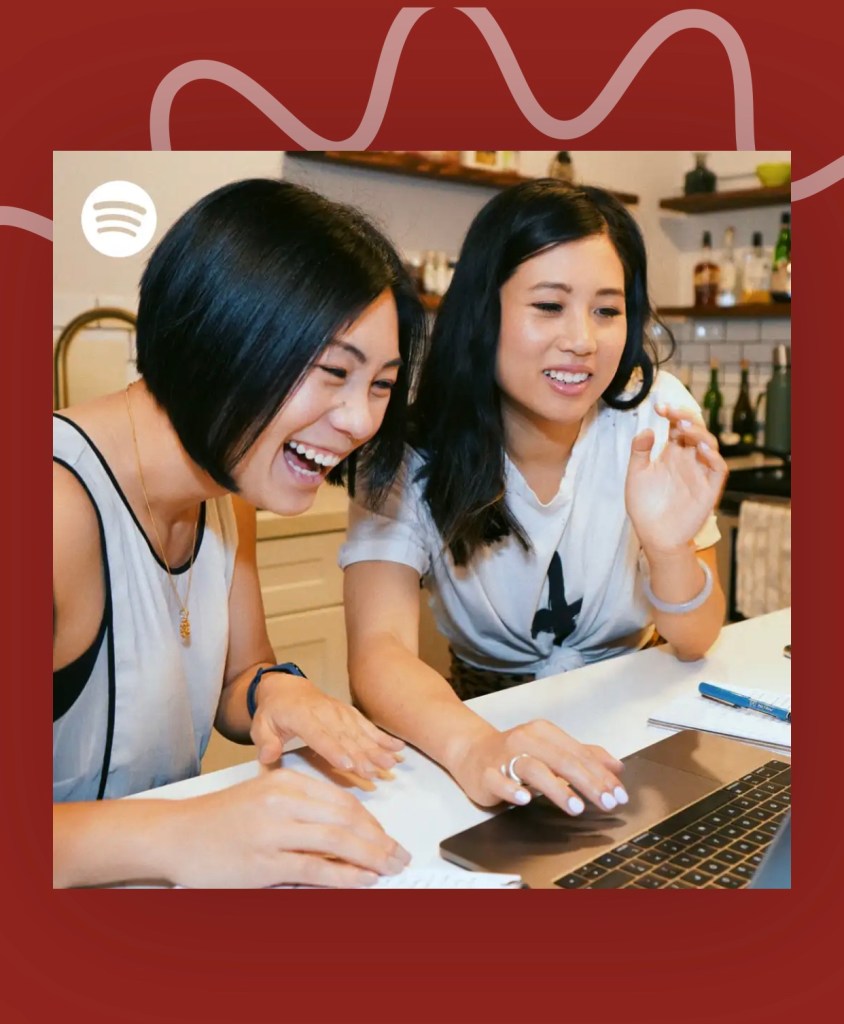 A picture of two women smiling in front of a laptop